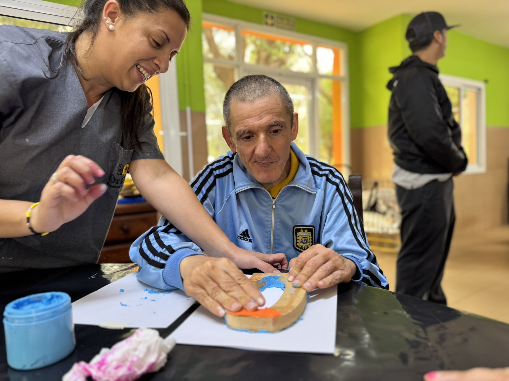 Residente pintando la L con esponja